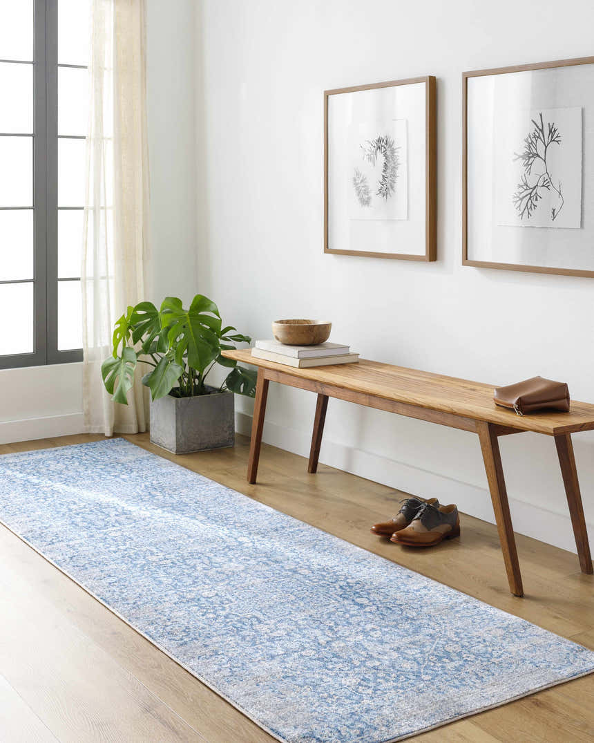 Entryway with a Yorkana Distressed Blue Rug runner, wood bench, monstera plant, and framed botanical prints. Roomscene-Runner