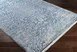 Close-up of the Yorkana Distressed Blue Rug showing its traditional, vintage pattern and soft blue, beige, and gray colors. Corner