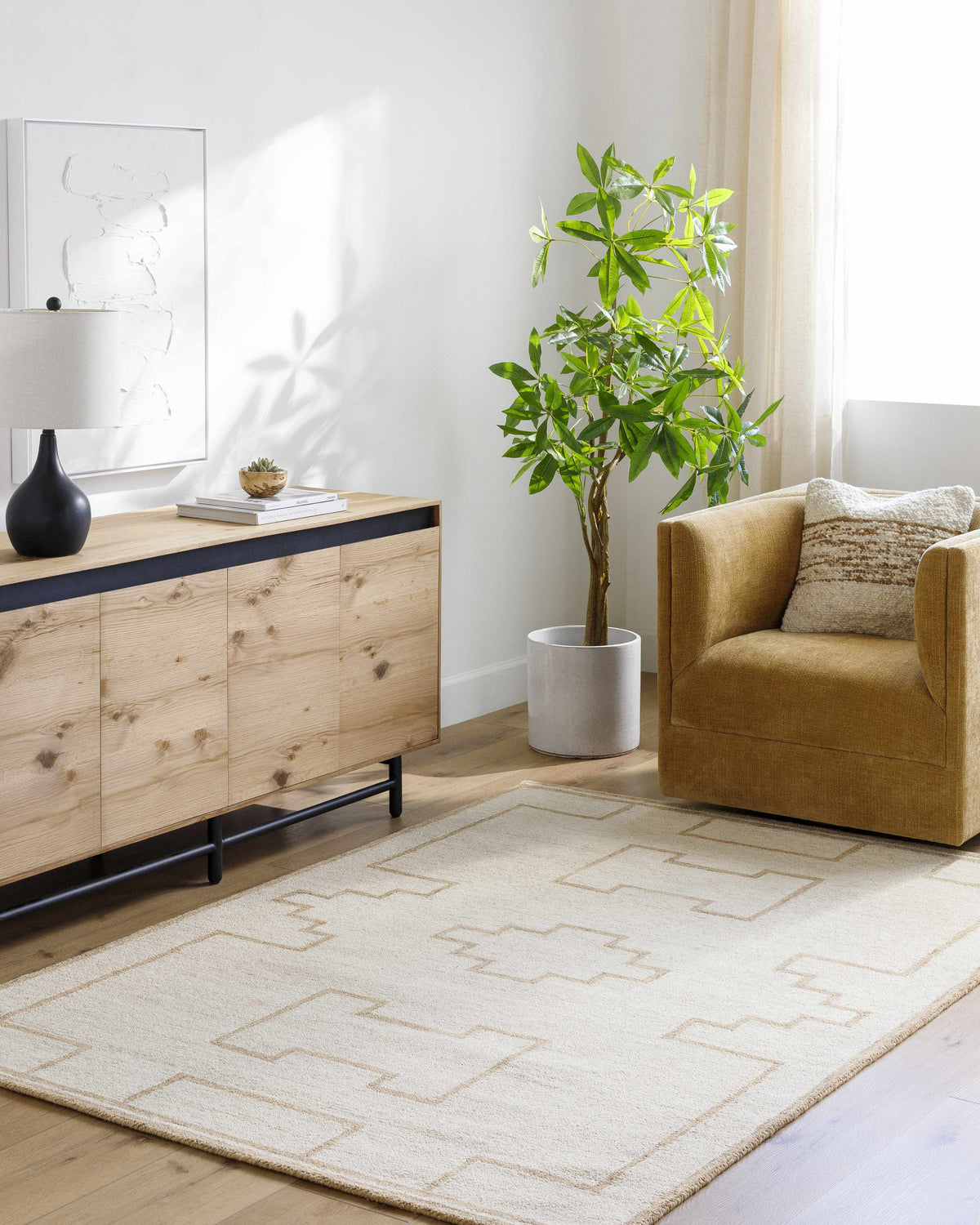 Living room scene with a light ash Yudai Area Rug, wood cabinet, tan chair, and plant. Roomscene-Rectangle
