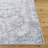 Close-up of the Yoshi Washable Area Rug in denim, cream, and gray. Traditional, farmhouse style rug with a detailed pattern. Front