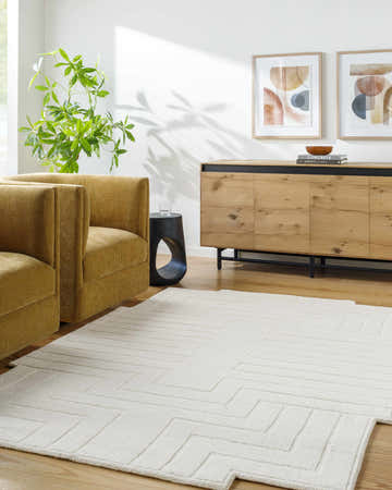 Living room scene with mustard armchairs and light wood furniture featuring the Yavor White Geometric Area Rug. Roomscene-Rectangle