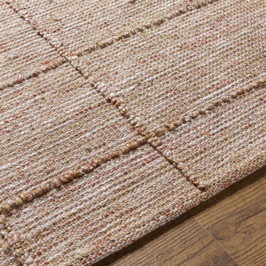 Close-up of the hand-woven Zana Area Rug showing its brown, tan, off-white, and burgundy color palette and textured jute blend. Texture