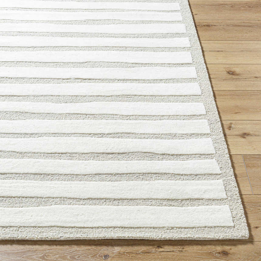 Close-up of the Zerah Area Rug, a hand-tufted wool rug with a contemporary striped design in ash, light silver, and white. Front