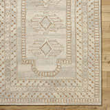 Close-up of the hand-tufted Zlata Area Rug. Farmhouse style with geometric brick red and tan pattern on pearl wool. Corner