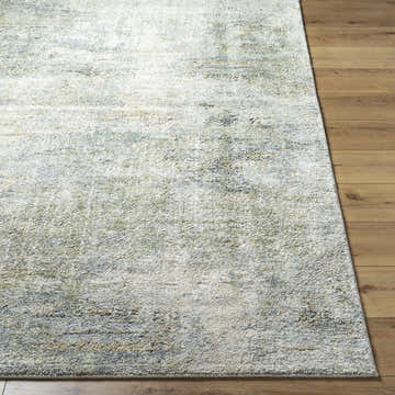 Close-up of a Zetna Thick Luxe Rug on wood floor. Beige, gray, olive, and teal hues create a contemporary abstract design. Front