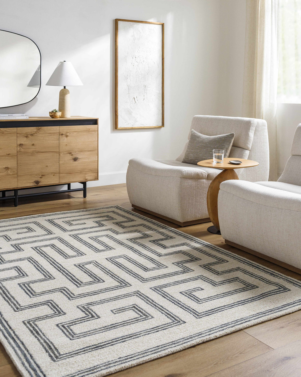 Living room scene with gray and light silver Zhang Area Rug, wood cabinet, and neutral armchairs. Roomscene-Rectangle