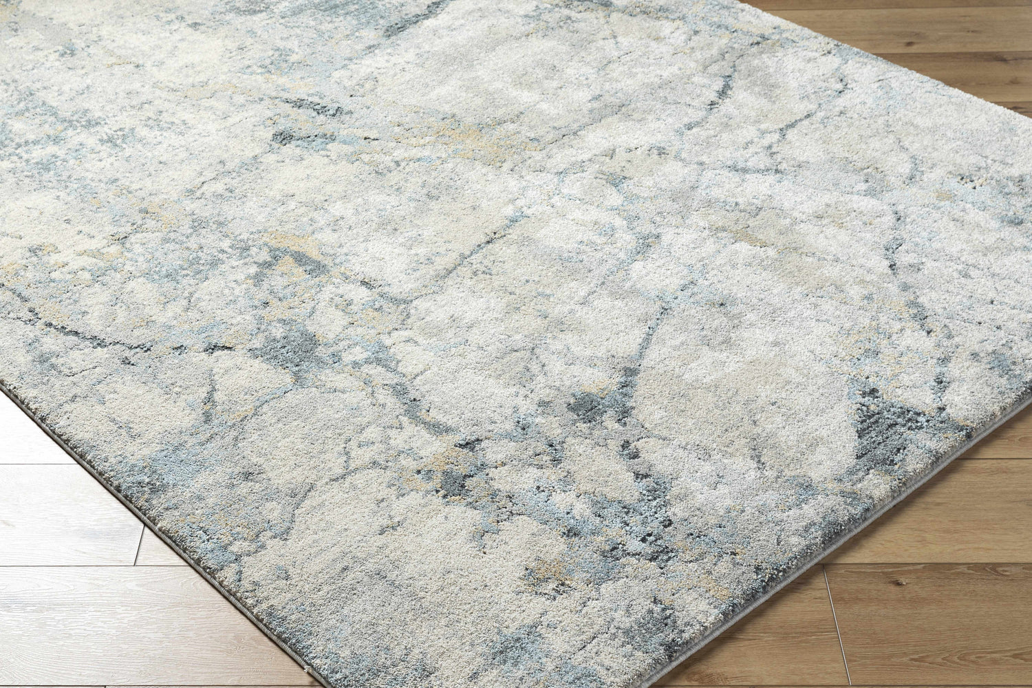 Close-up of the Urowo Light Gray Thick Luxe Rug showing its cream, gray, and light blue contemporary pattern. Corner