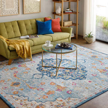 Living room scene with a green sofa and the blue, orange Zoar Area Rug. Roomscene-Rectangle