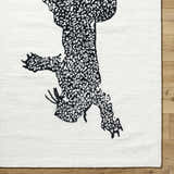 Close-up of the Zosia Area Rug, a hand-tufted wool rug with a black abstract animal design on an off-white background. Corner